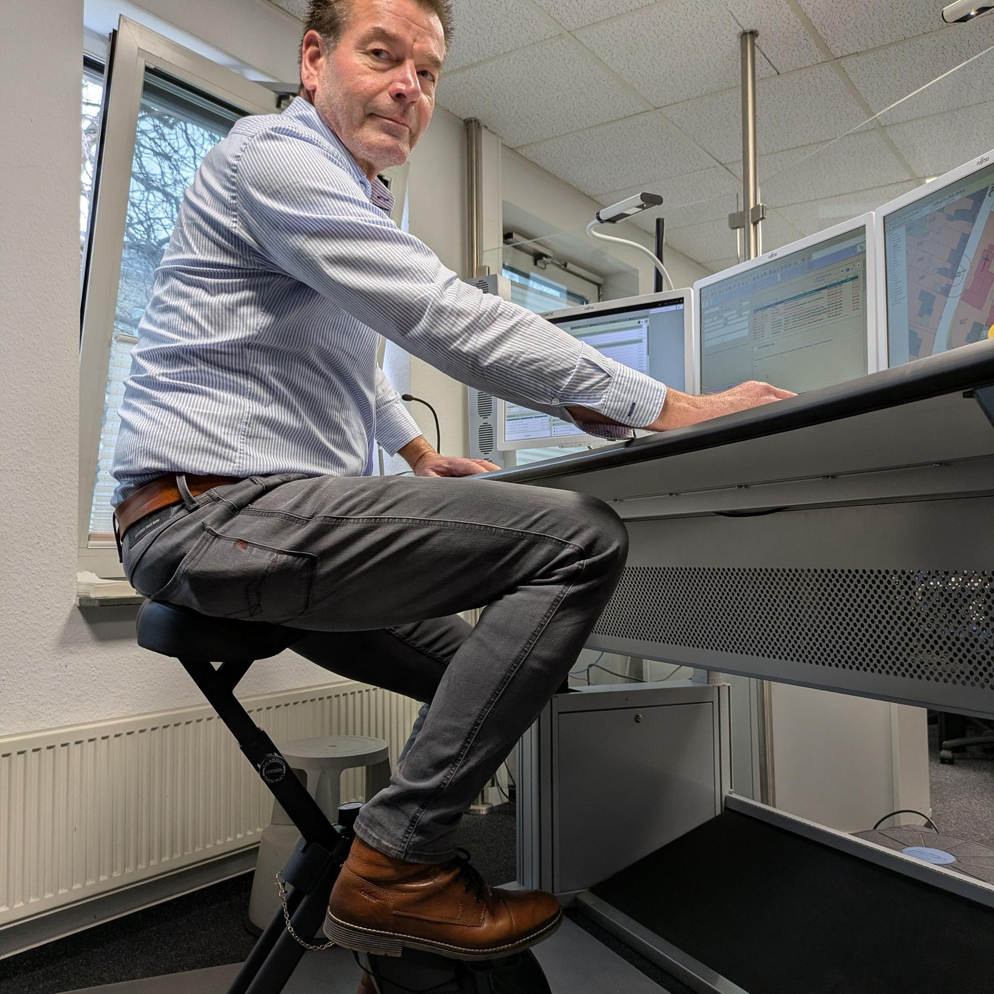 Ulrich Linden sitzt vor Computern und tritt leicht in die Pedale.