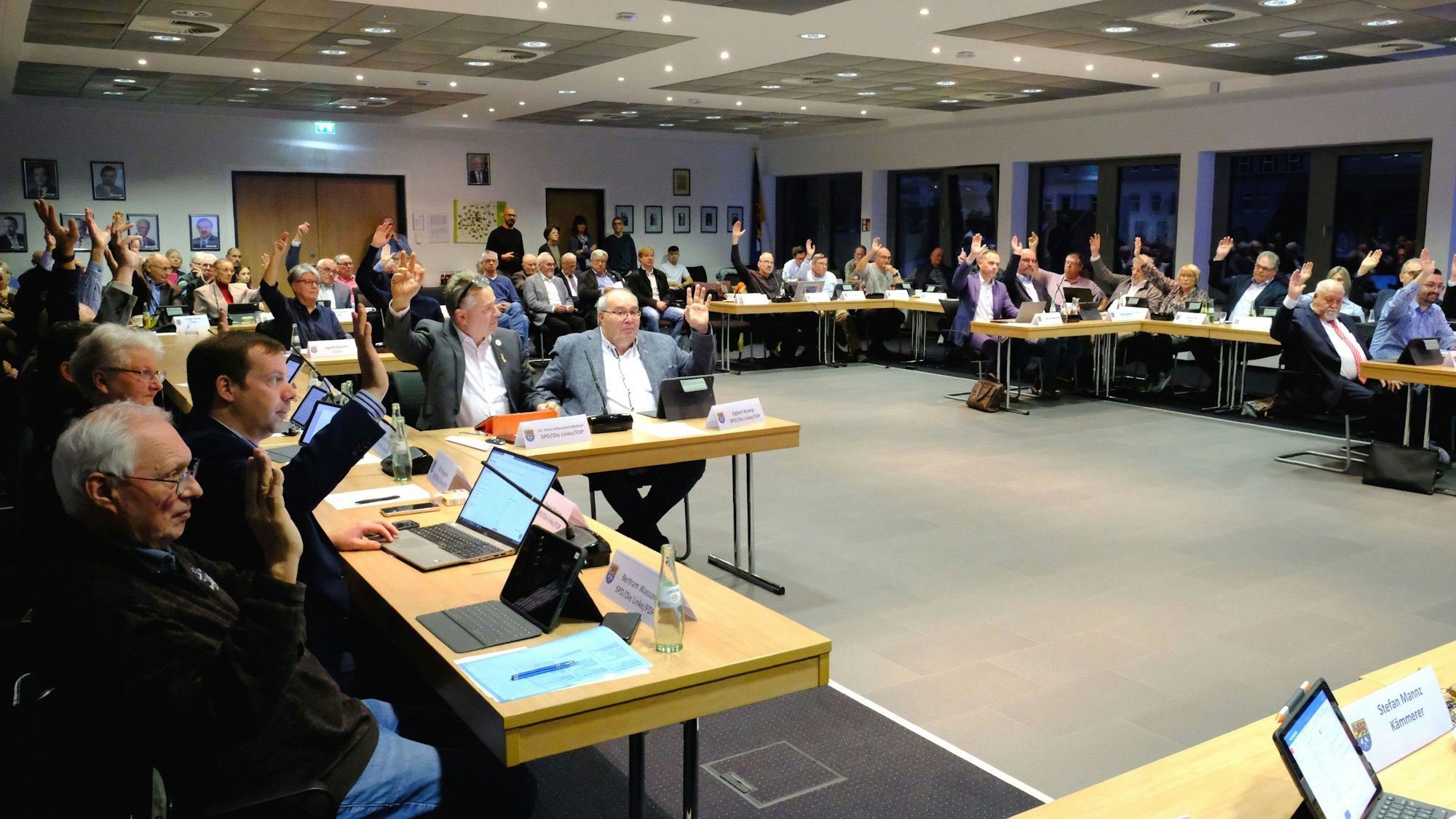 Bei einer Sitzung des Mechernicher Stadtrats stimmen die Ratsmitglieder per Handzeichen ab.