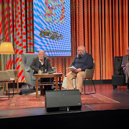 Zwei Herren an einem Tisch, ein Mann und eine Frau an einem anderen.
