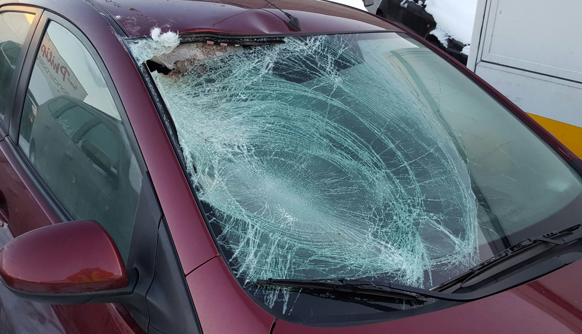 Ein Auto mit zerstörter Windschutzscheibe.
