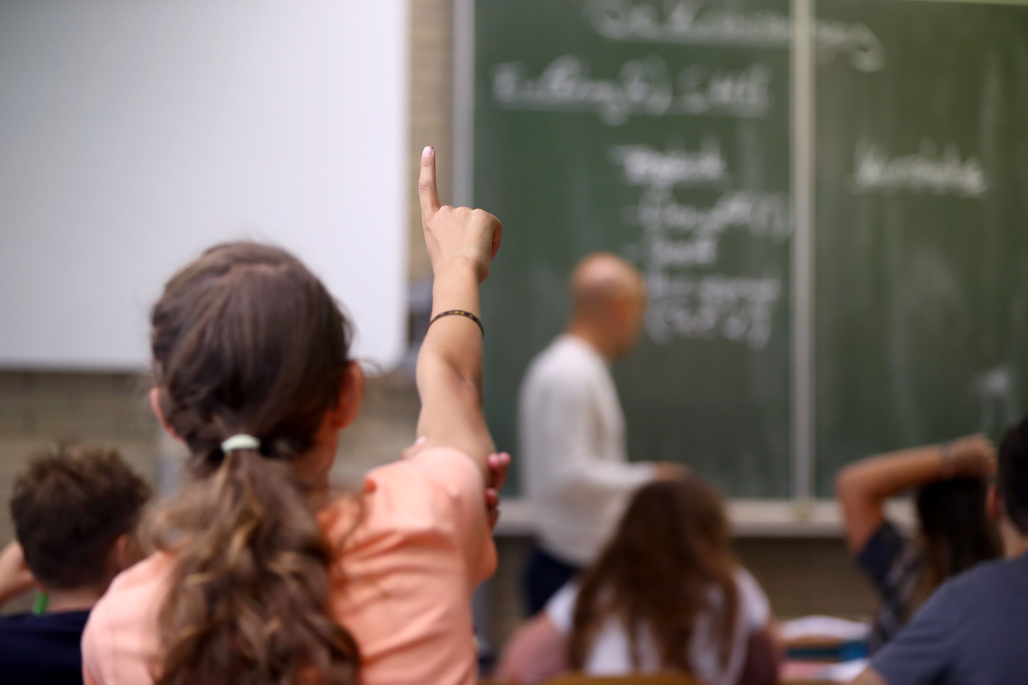 Eine Schülerin der fünften Klasse eines Gymnasiums meldet sich im Unterricht.