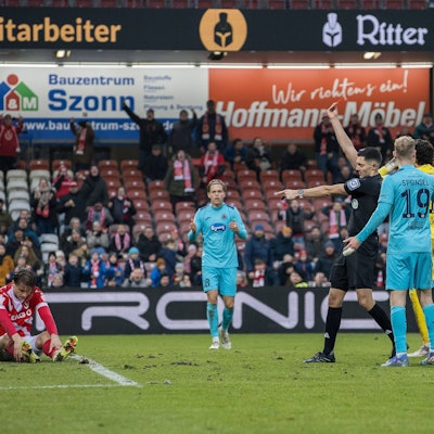 Schiedsrichter Timon Schulz zeigt auf den Elfmeterpunkt und Viktorias Florian Engelhardt (nicht im Bild) die Rote Karte.