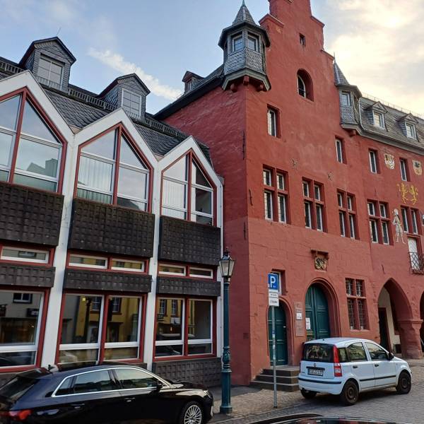 Das Bild zeigt das Rathaus, davor stehen Autos.