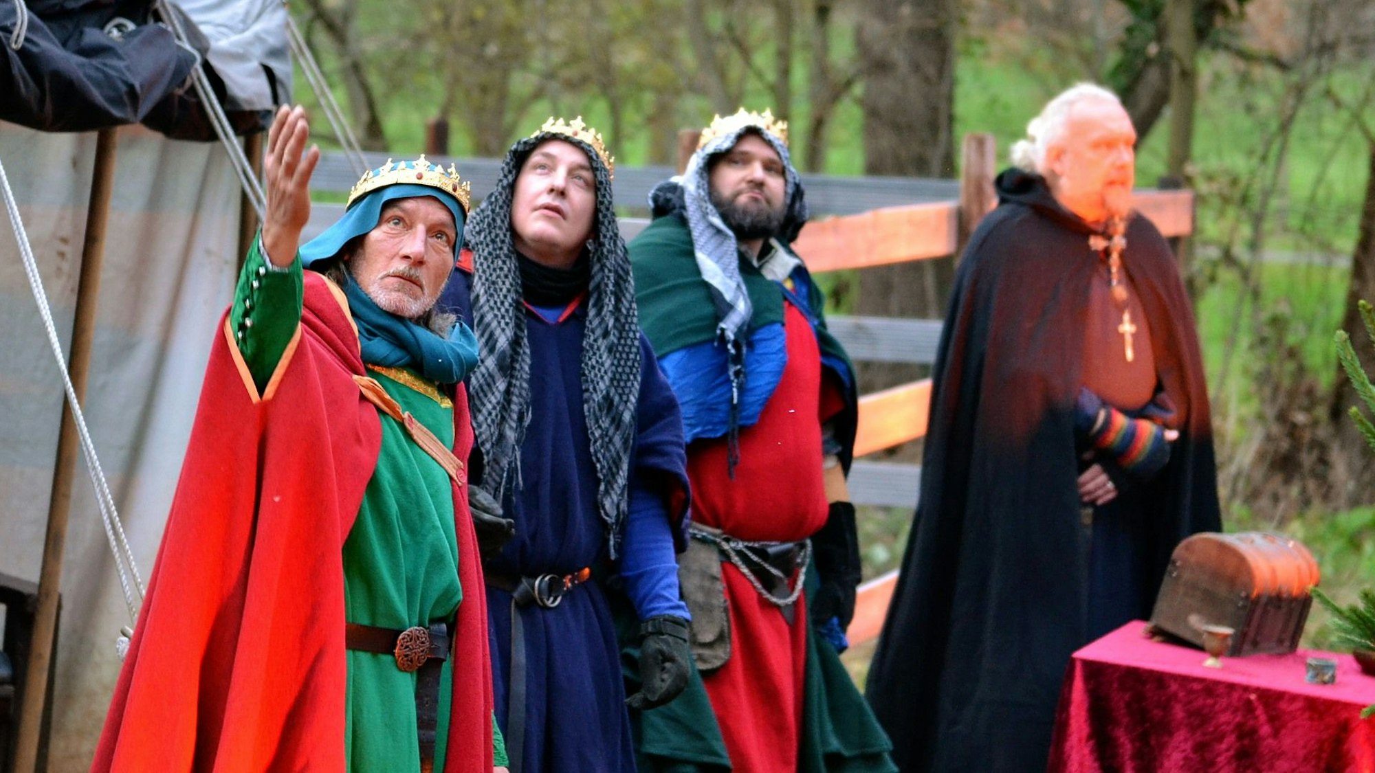 Drei Männer, verkleidet als Heilige Könige, und ein Erzähler beim Krippenspiel auf Burg Satzvey.