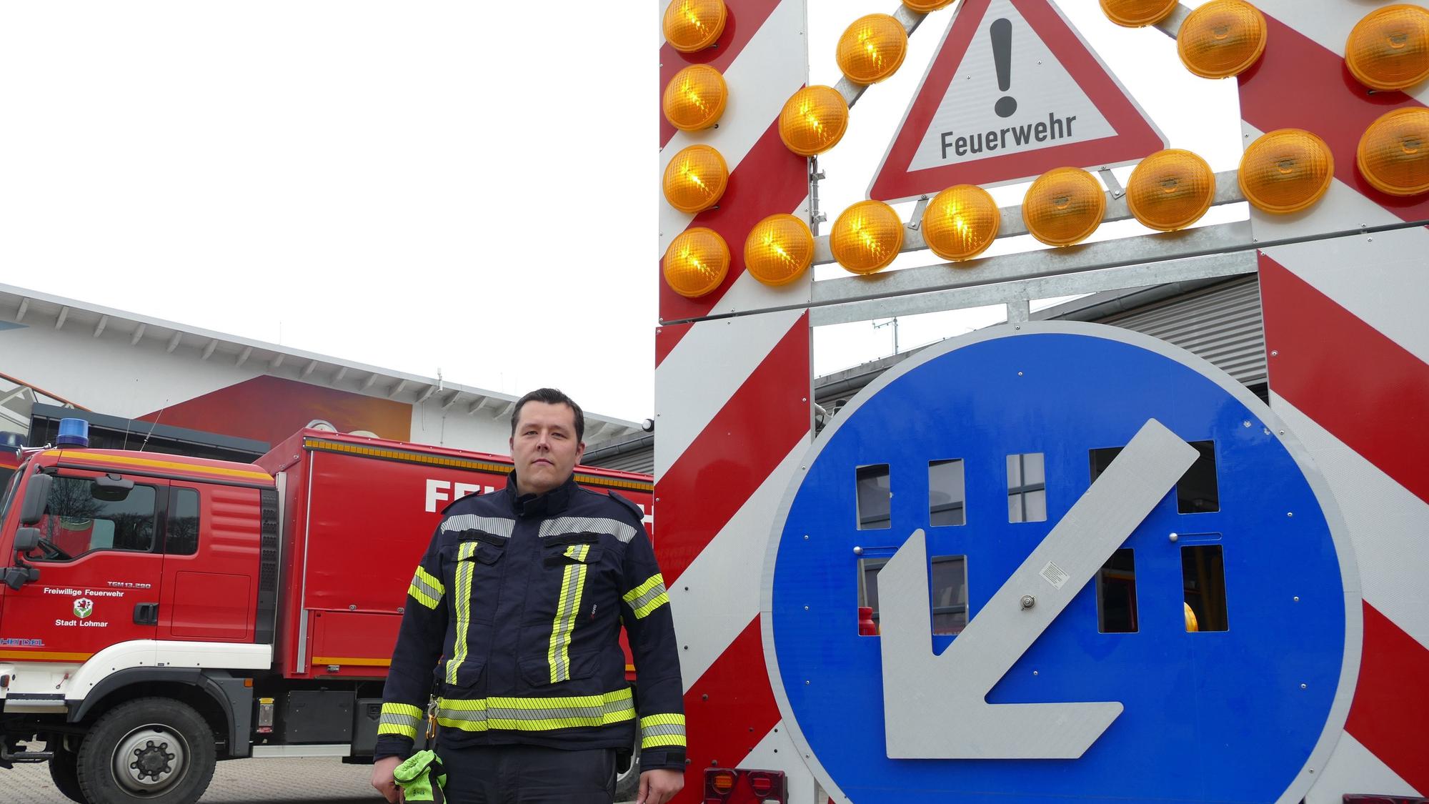 Christopher Wegemann, stellvertretender Wehrleiter der Feuerwehr Lohmar, steht vor einer Verkehrswarntafel, die die Stadt nach einem Eigenunfall vor acht Jahren gekauft hat.