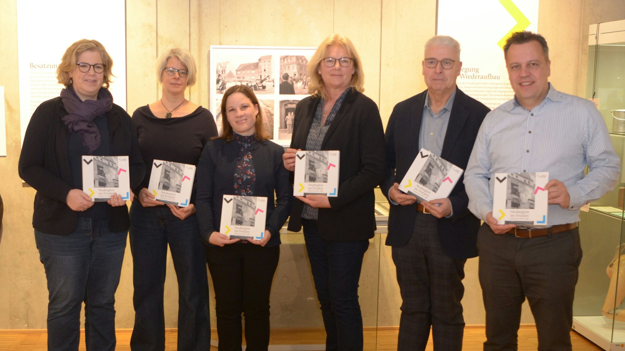 Anke Asfur (v.l.), Suna Niemetz, Maja Kützemeier, Heike Lützenkirchen, Kurt Lingscheidt und Sacha Reichelt halten jeweils den neuen Katalog zur Sonderausstellung in den Händen und schauen in die Kamera.