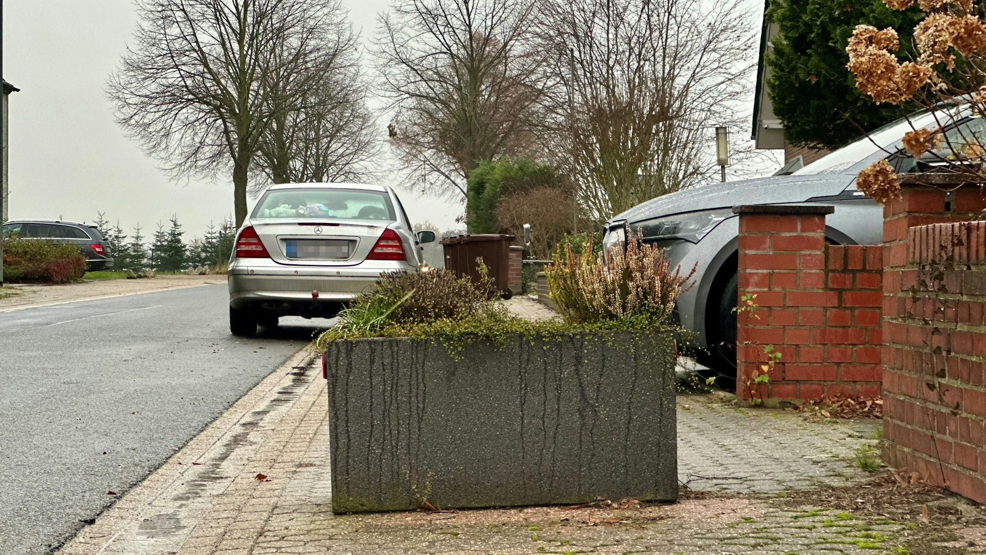 Ein Blumenkübel steht auf einem Bürgersteig.