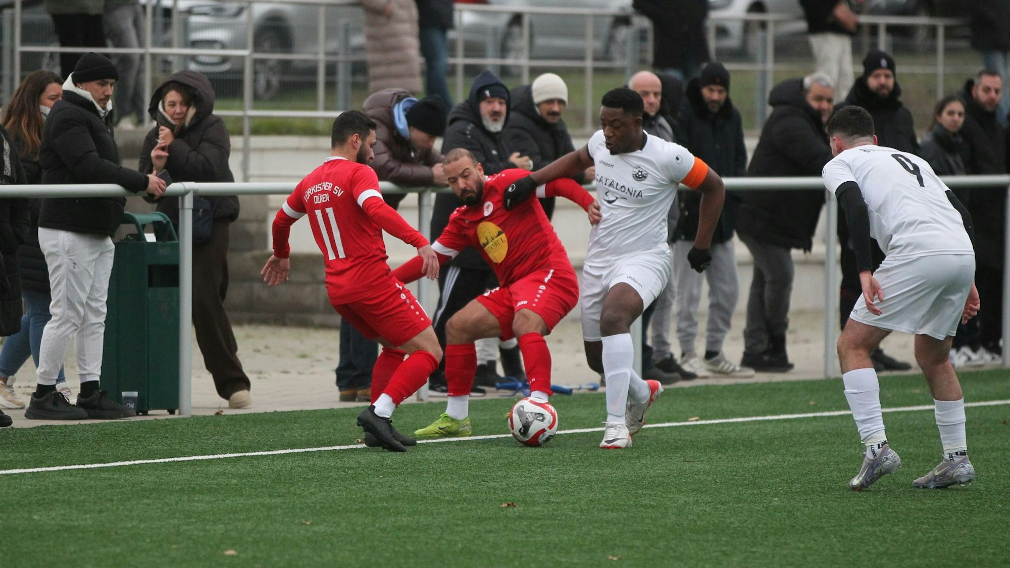 Das Bild zeigt den Fußballer des SV Bessenich im Duell mit gleich zwei Gegenspielern aus Weiden.