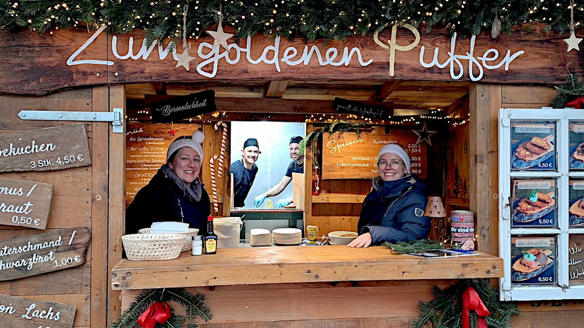 Das Bild zeigt eine Holzbude, die weihnachtlich verziert ist.