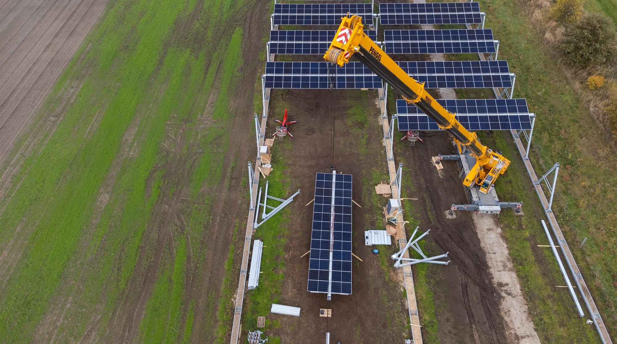 Lüchow: Mit einem Kran wird eine Agrar-Photovoltaik-Anlage montiert (Aufnahme mit einer Drohne).
