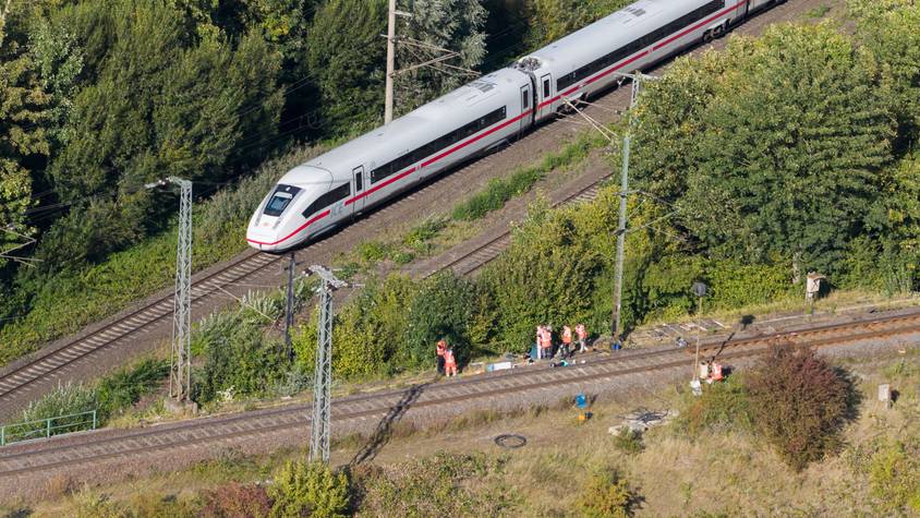 Mitarbeiter der Deutschen Bahn arbeiten nach einem Brand an einer Bahnstrecke in der Nähe eines Stellwerkes