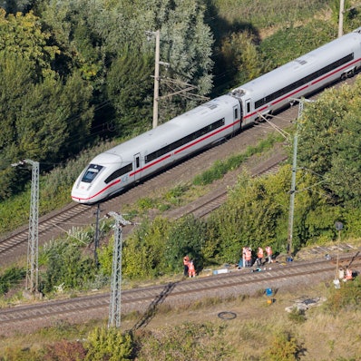 Mitarbeiter der Deutschen Bahn arbeiten nach einem Brand an einer Bahnstrecke in der Nähe eines Stellwerkes