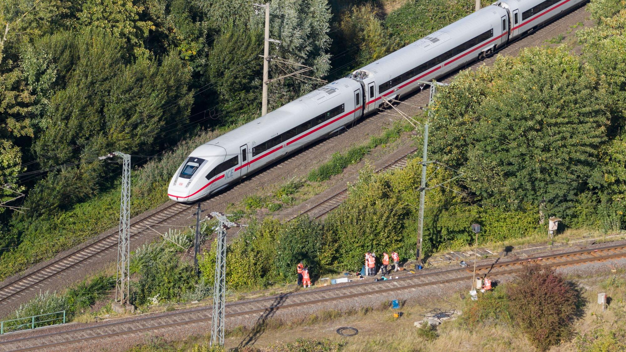 Mitarbeiter der Deutschen Bahn arbeiten nach einem Brand an einer Bahnstrecke in der Nähe eines Stellwerkes