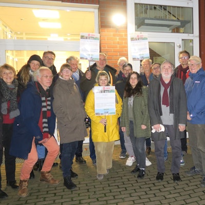 Eine Gruppe Menschen steht vor dem Eingang zum Ehrenfelder Bezirksrathaus.