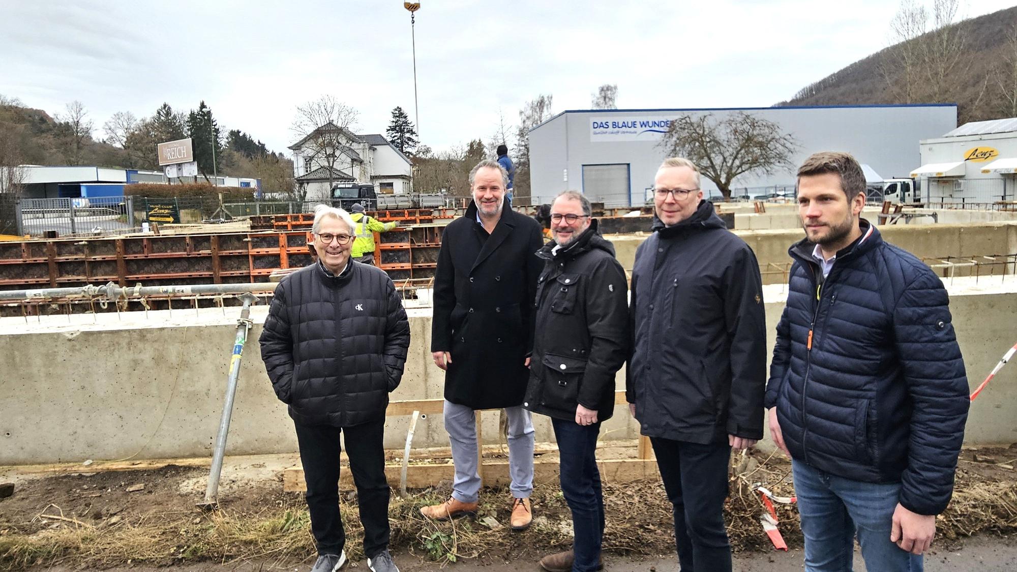Fünf Männer stehen nebeneinander vor der Baustelle.