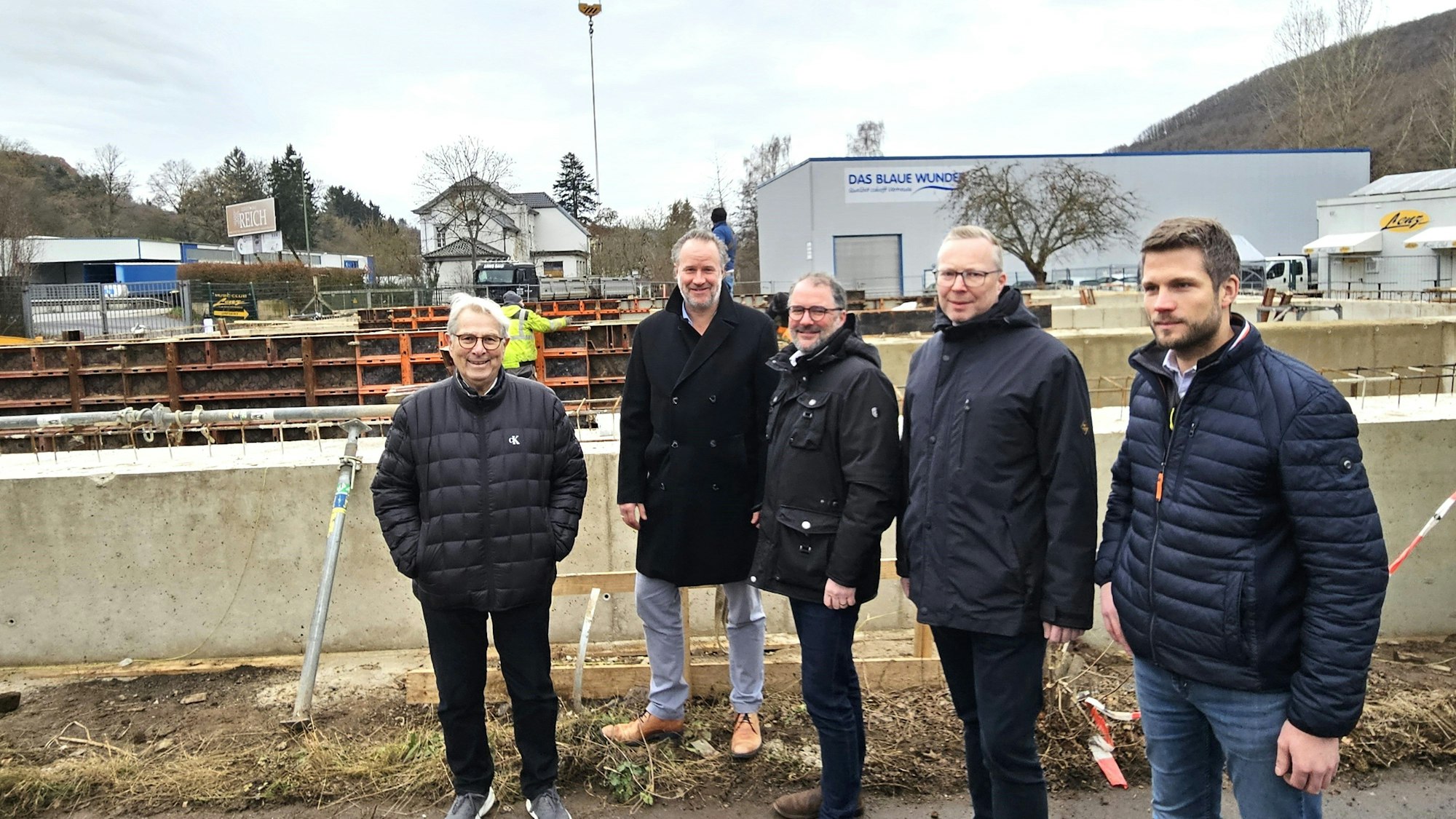 Fünf Männer stehen nebeneinander vor der Baustelle.