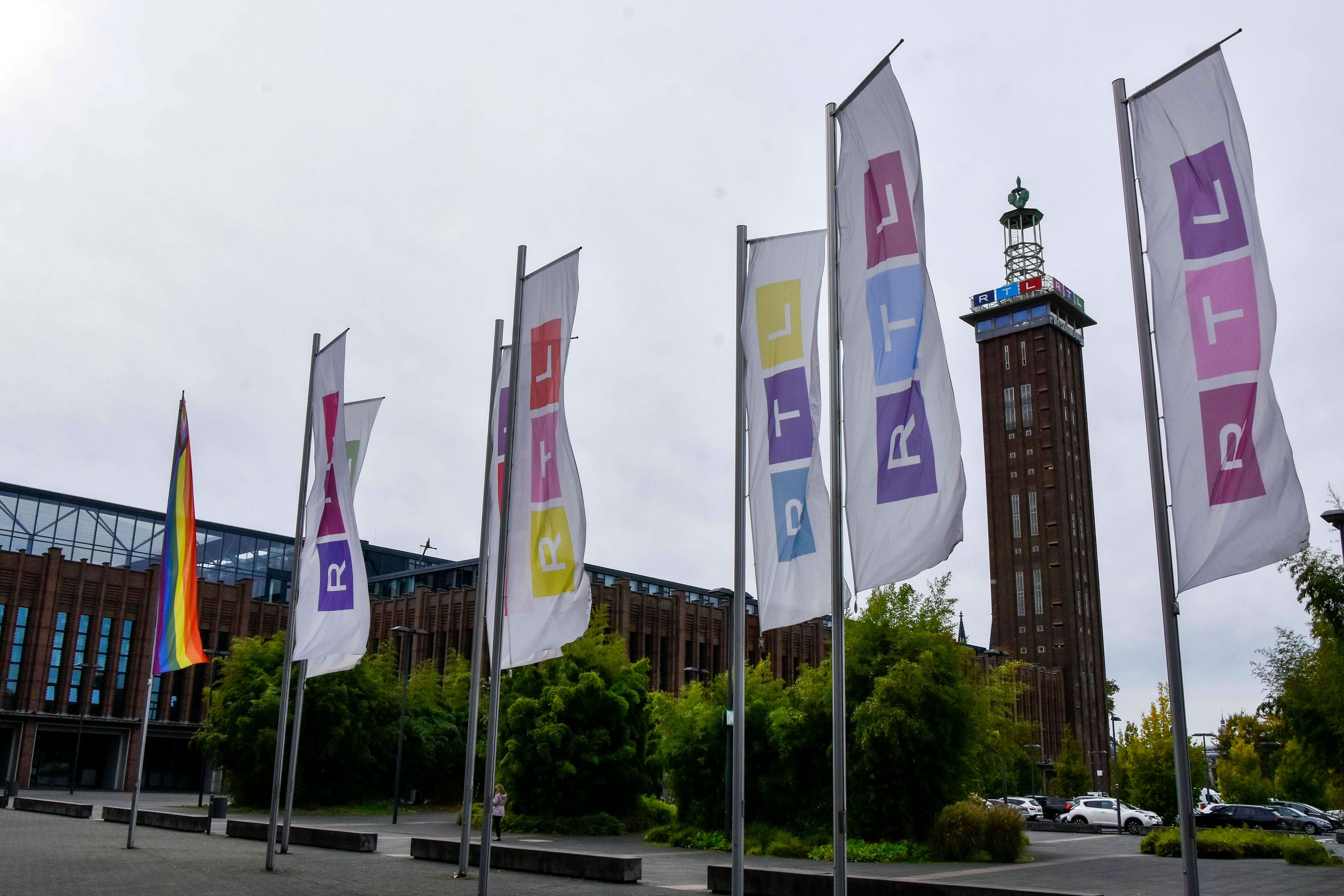 Vor dem Kölner Messe-Turm wehen bunte Fahnen mit dem RTL-Logo in Köln-Deutz am Sitz der RTL Group Deutschland.