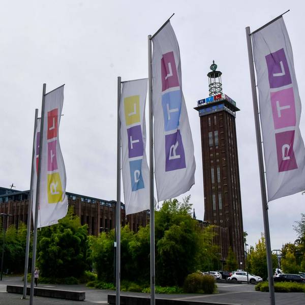 Vor dem Kölner Messe-Turm wehen bunte Fahnen mit dem RTL-Logo in Köln-Deutz am Sitz der RTL Group Deutschland.