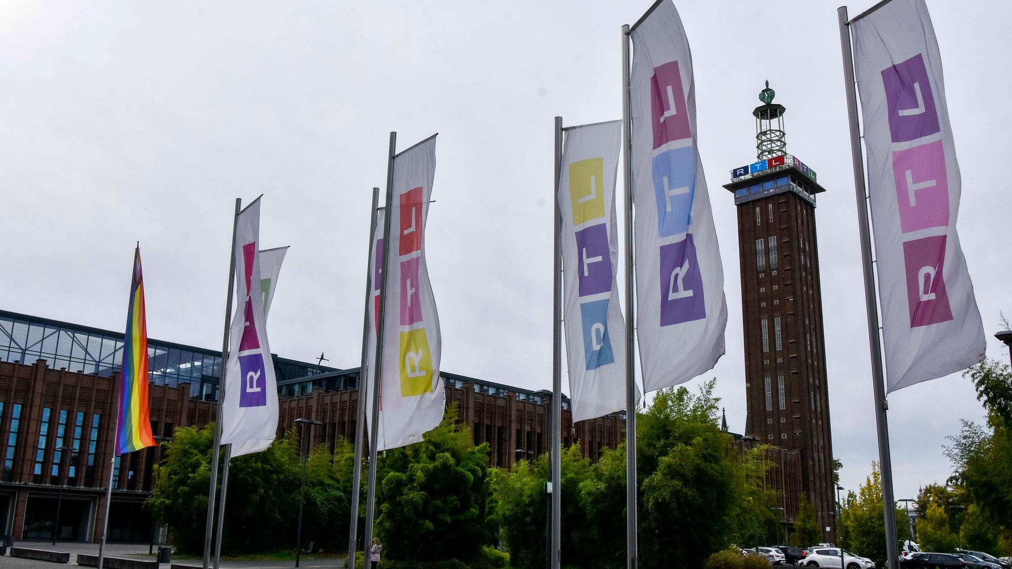 Vor dem Kölner Messe-Turm wehen bunte Fahnen mit dem RTL-Logo in Köln-Deutz am Sitz der RTL Group Deutschland.