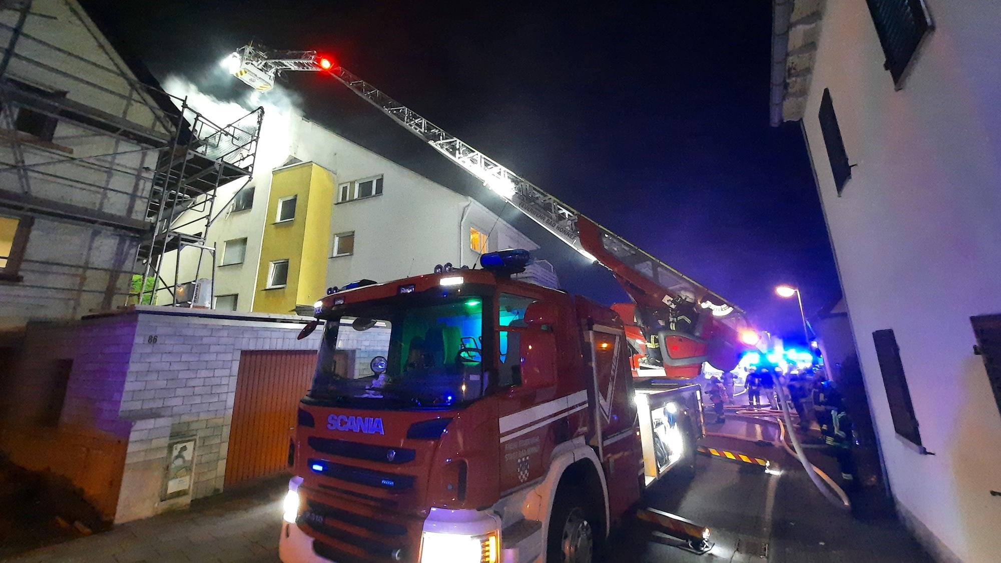 Die Drehleiter der Feuerwehr an einem Mehrfamilienhaus.