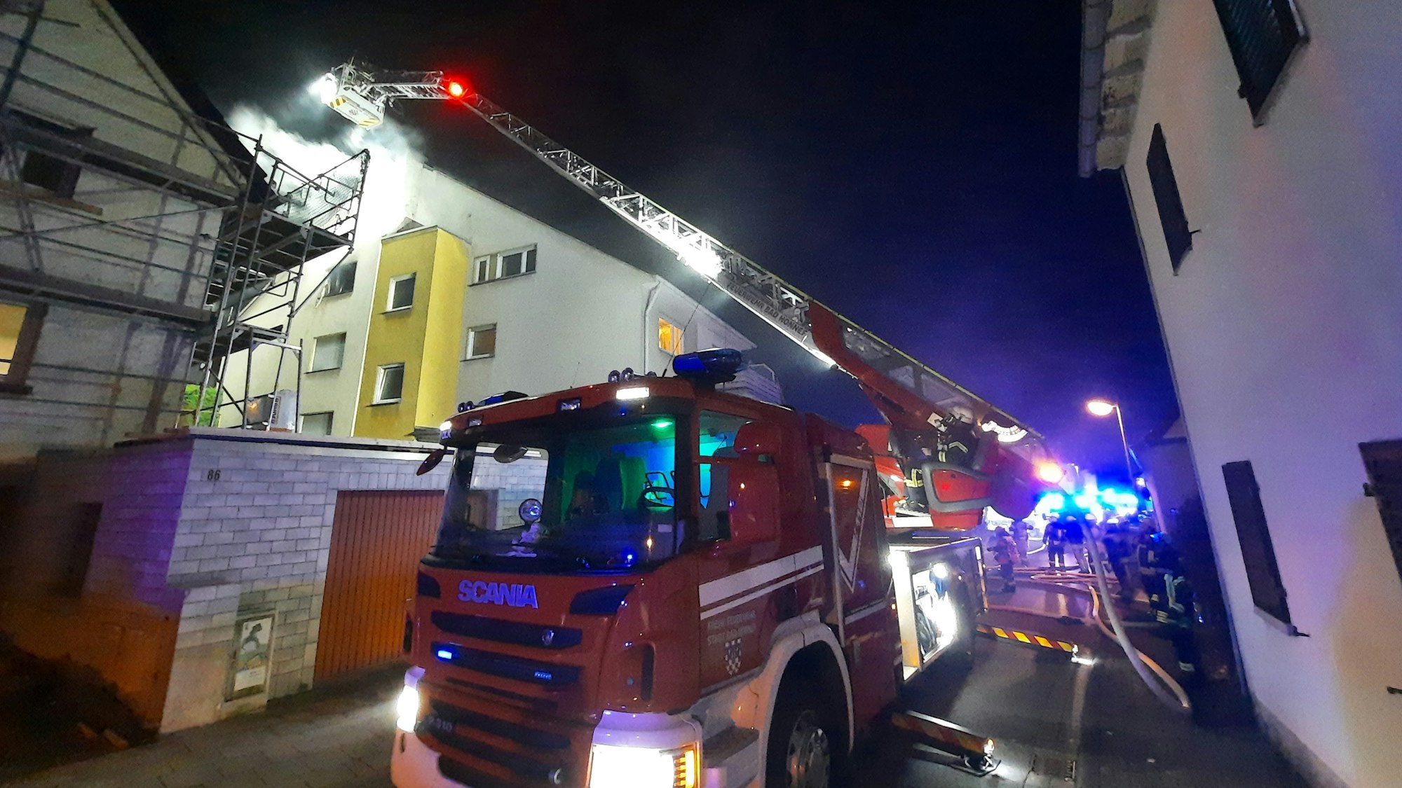 Die Drehleiter der Feuerwehr an einem Mehrfamilienhaus.