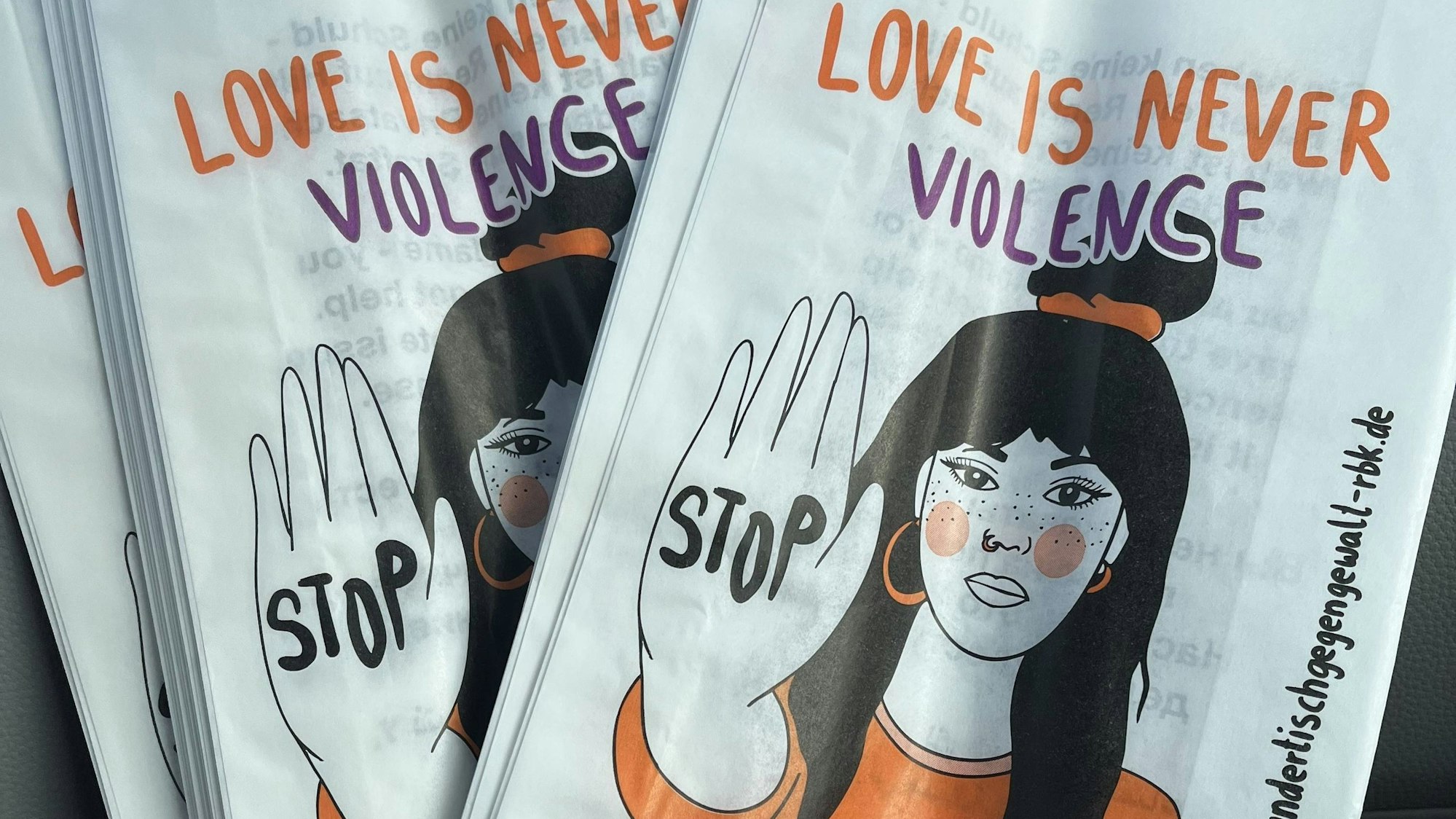 Brötchentüten, auf denen eine Frau ihre Hand hebt. Auf dieser steht „Stop“.