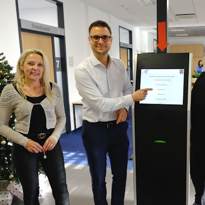Michael Fingel und drei Mitarbeiterinnen stehen an einem digitalen Bildschirm im Rathaus in Mechernich.
