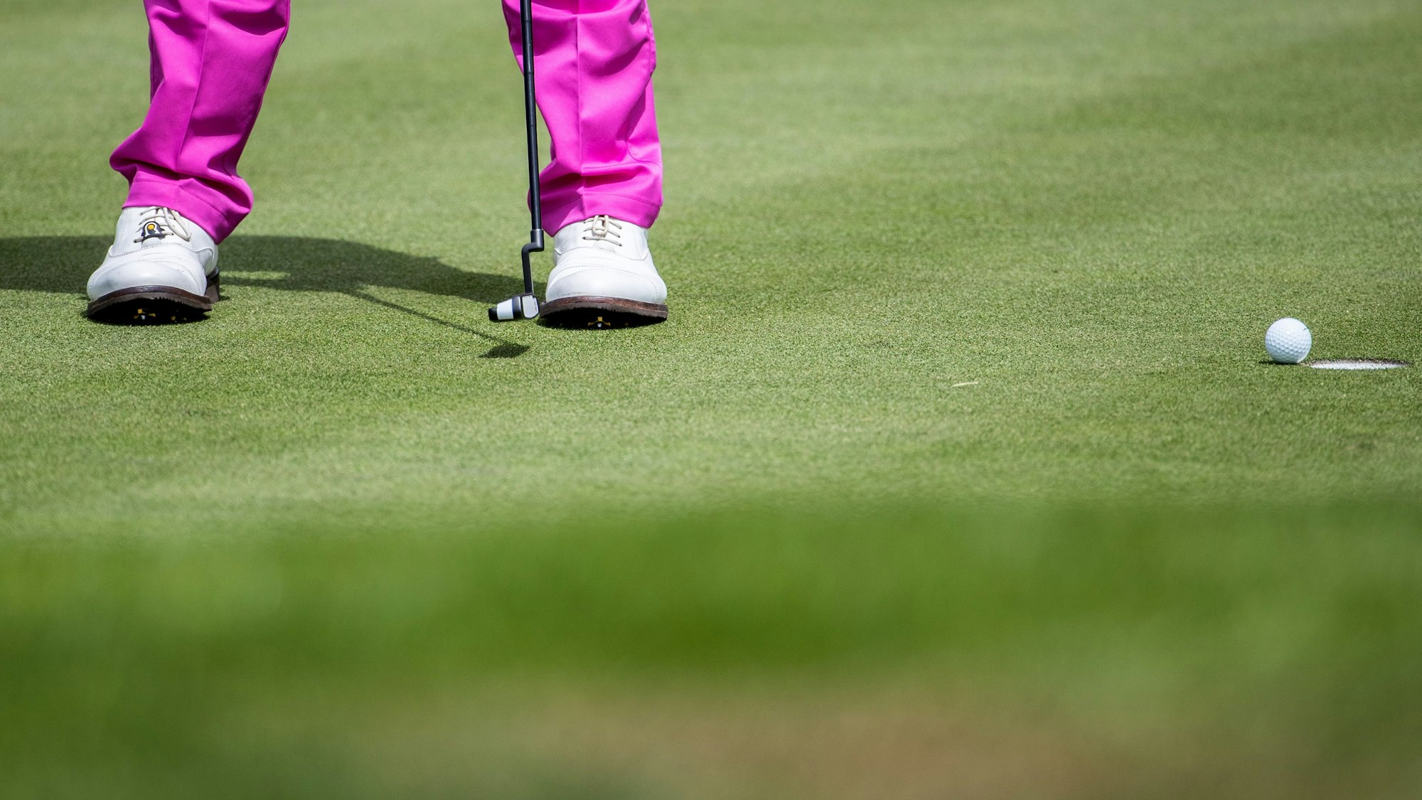 Ein Golfspieler schlägt einen Ball ins Loch.