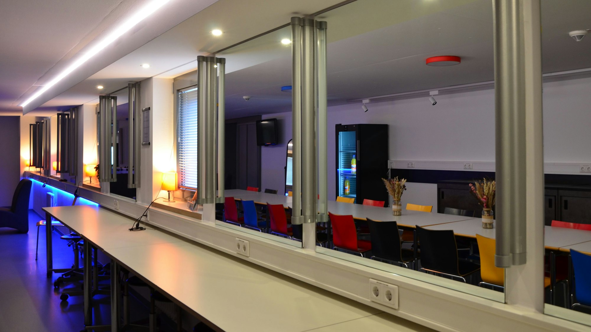 Zu sehen ist Raum mit Spiegel und Tischen.