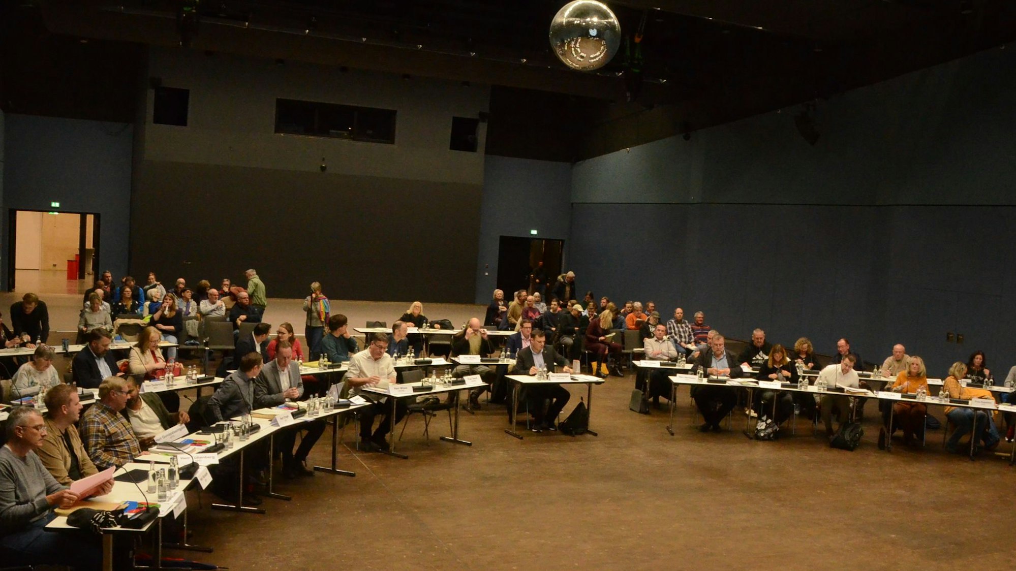 Männer und Frauen bei einer Sitzung in einer großen Veranstaltungshalle