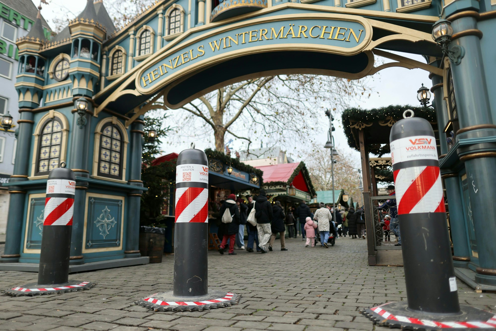 Antiterror-Poller stehen vor dem Weihnachtsmarkt „Heinzels Wintermärchen“ auf dem Kölner Heumarkt.