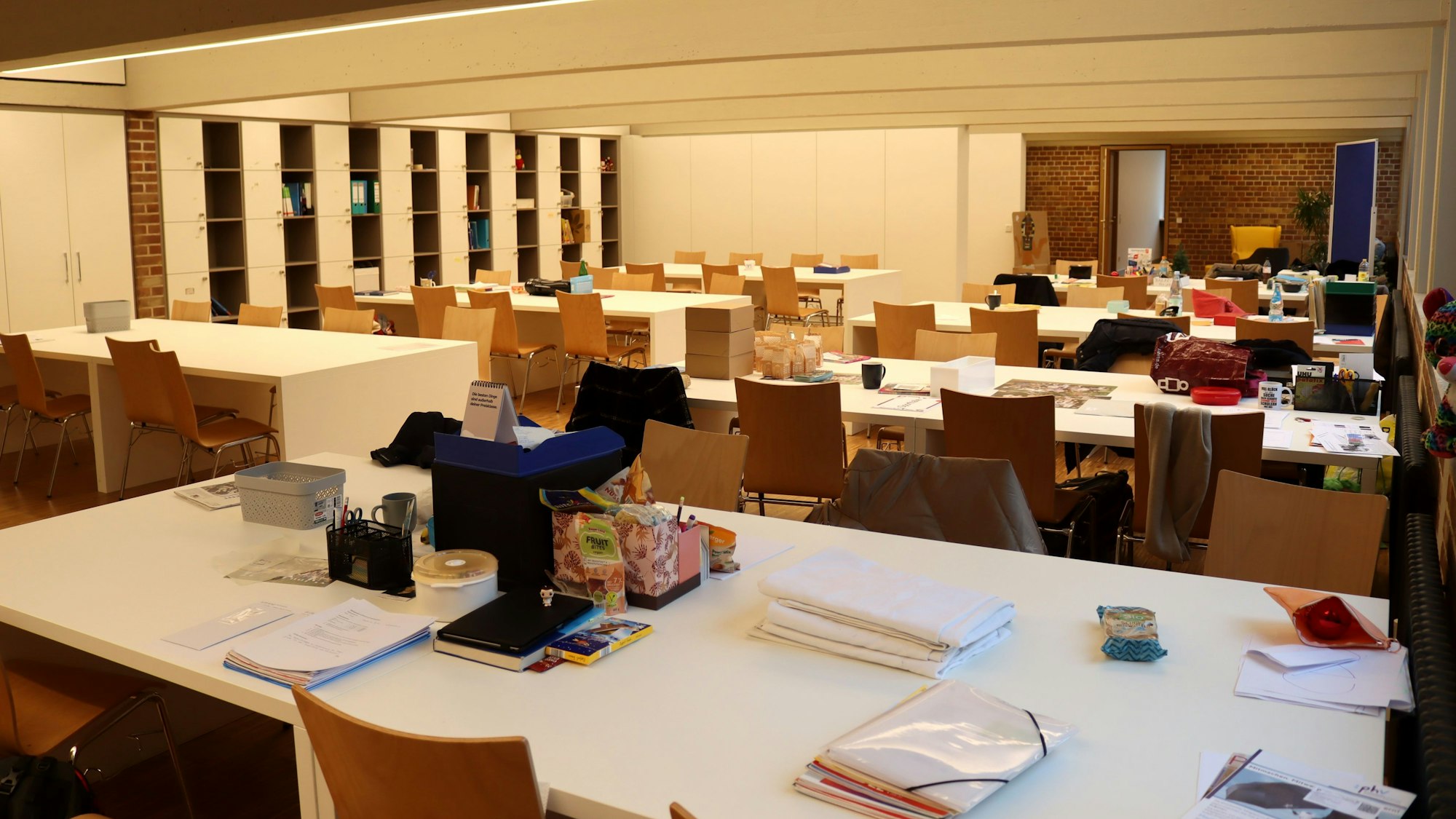 Zwar befindet sich kein Lehrer im Lehrerzimmer, aber auf den Tischen liegen Hefter, Blocks und sonstiges Arbeitsmaterial.