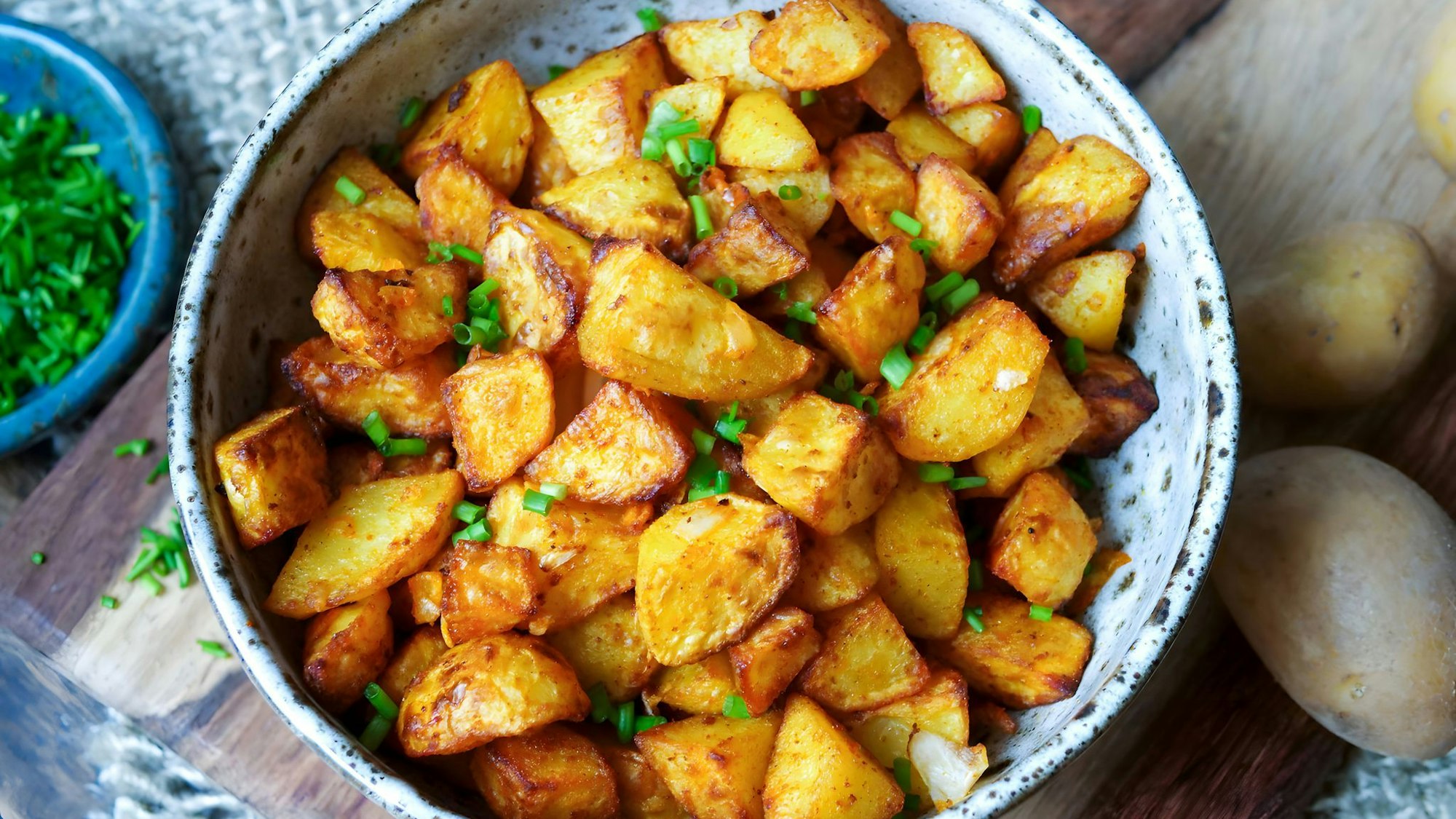 Nur kleine Mengen Fett bekommen Bratkartoffeln per Ölsprüher ab, werden mit Salz und Paprikapulver gewürzt und kommen in den Airfryer: Nach 25 Minuten sind die Kartoffelstücke richtig schön knusprig.