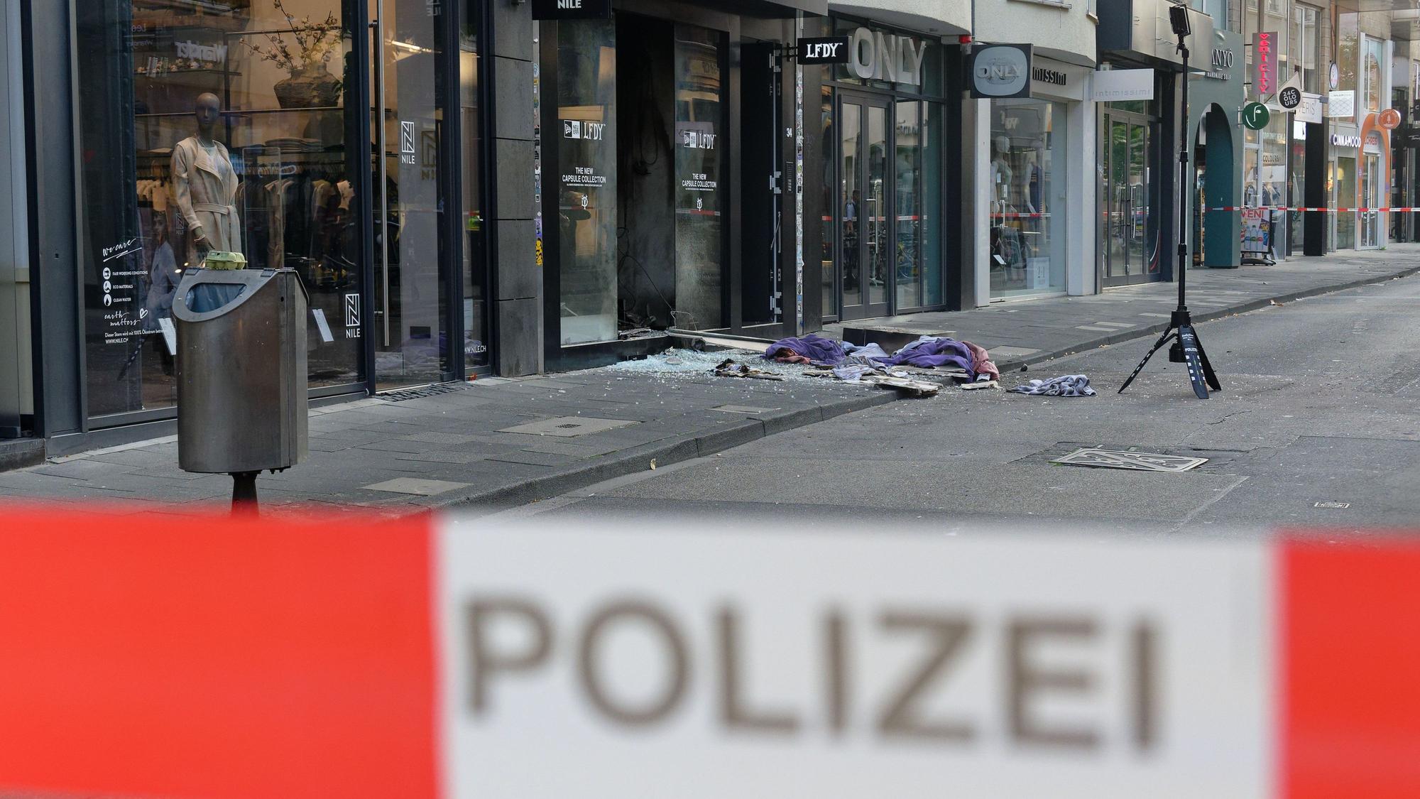 Scherben und Kleidungstücke liegen vor einem Geschäft in der Ehrenstraße in Köln. Auch hier kam es zu einer Explosion, die Ermittler Sermet A. zurechnen.