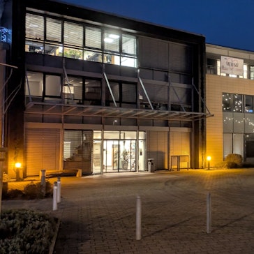 Das Mechernicher Rathaus in der Adventszeit: In der Abenddämmerung leuchtet ein mit Lichterketten geschmückter Weihnachtsbaum vor dem Verwaltungsgebäude.