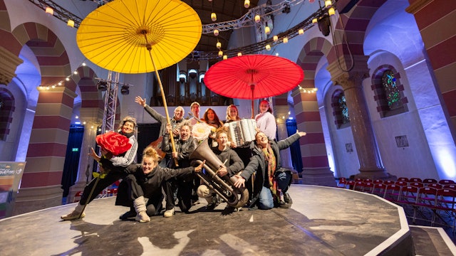 Die Künstlerinnen und Künstler treten auf einer kleinen Bühne in der Mitte der Kirche auf.