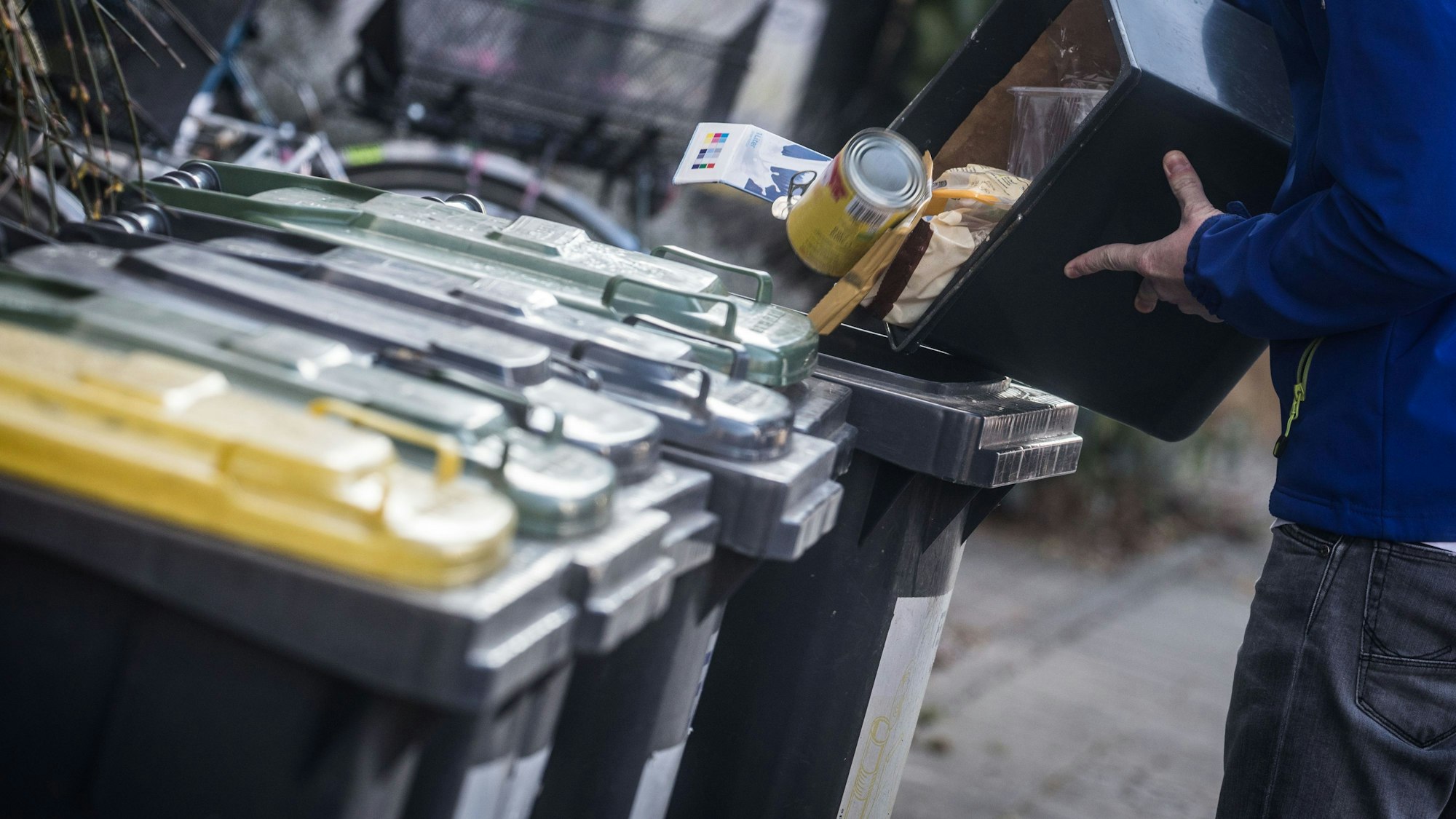 Vier Mülltonnen stehen nebeneinander.