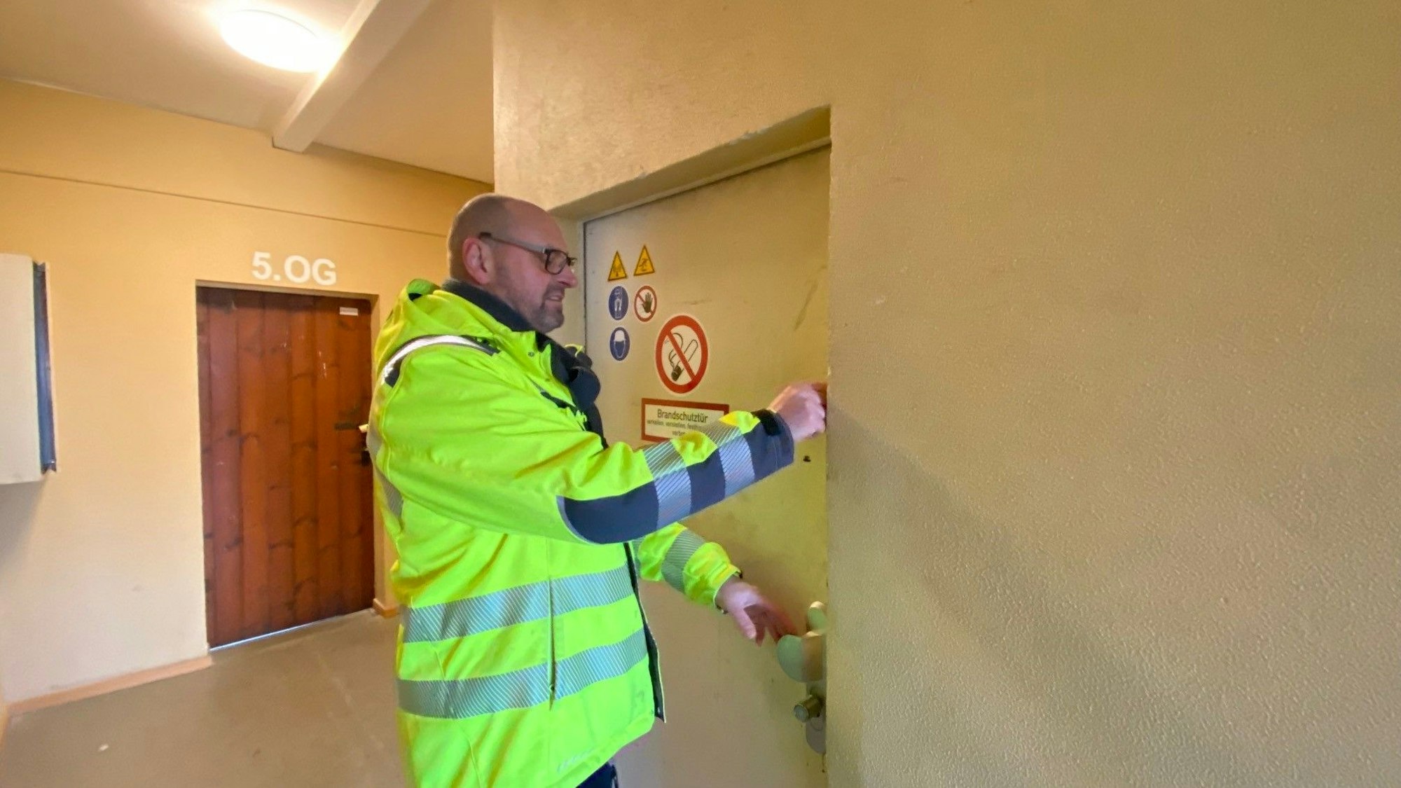 Zu sehen ist Eric König beim Öffnen einer Tür.