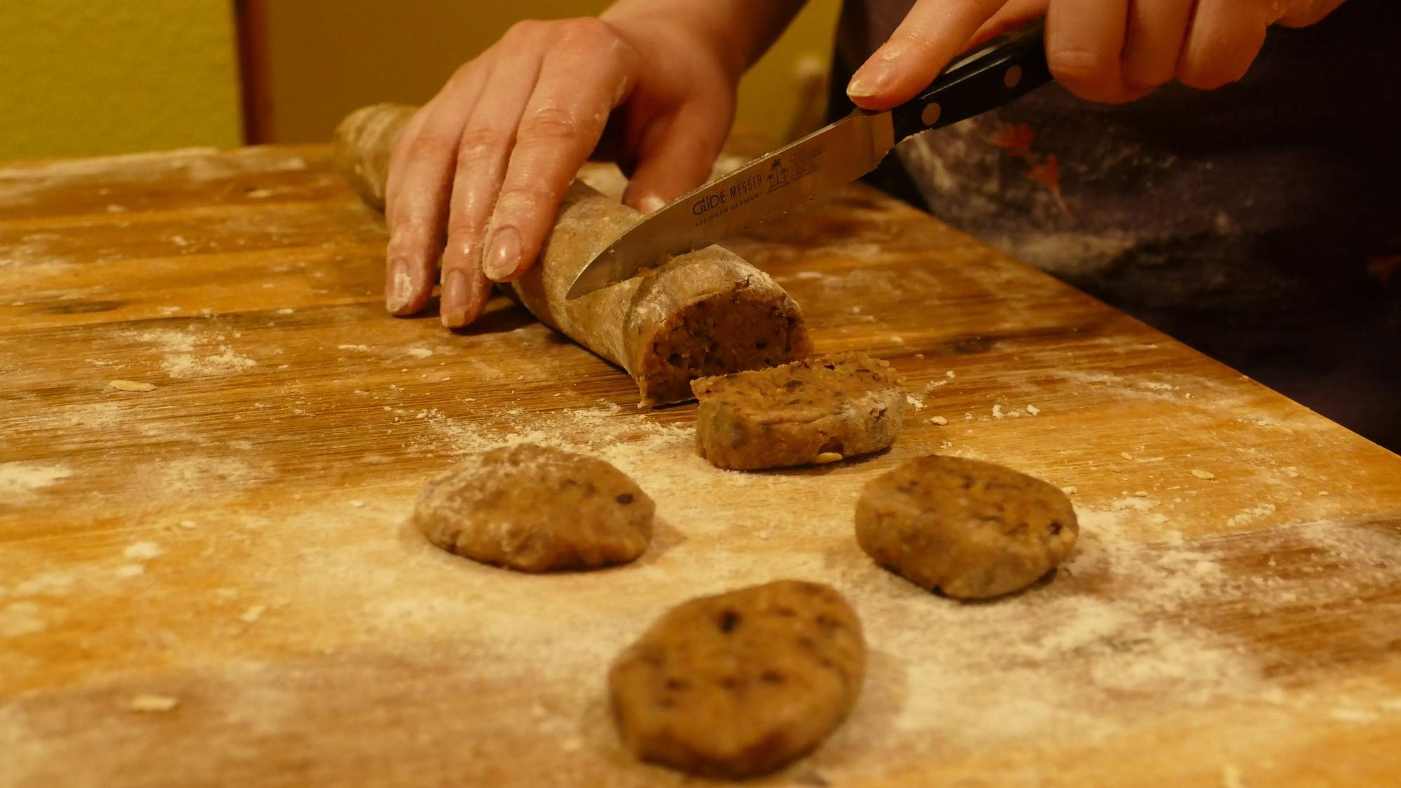 Die Schoko-Nuss-Plätzchen werden gerollt und einzeln abgeschnitten.