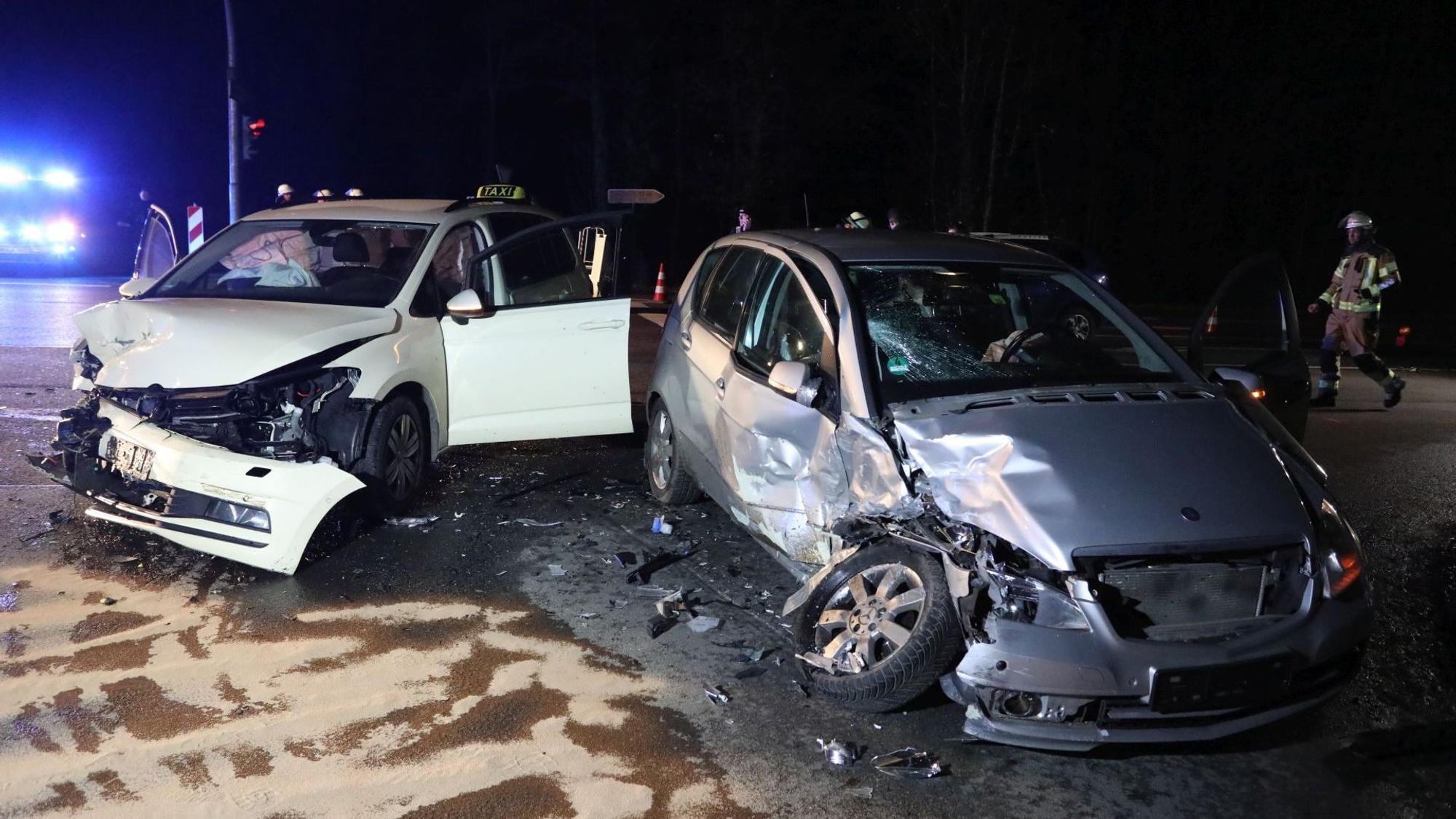 Zwei stark beschädigte Autos, im Hintergrund ein Feuerwehrmann.