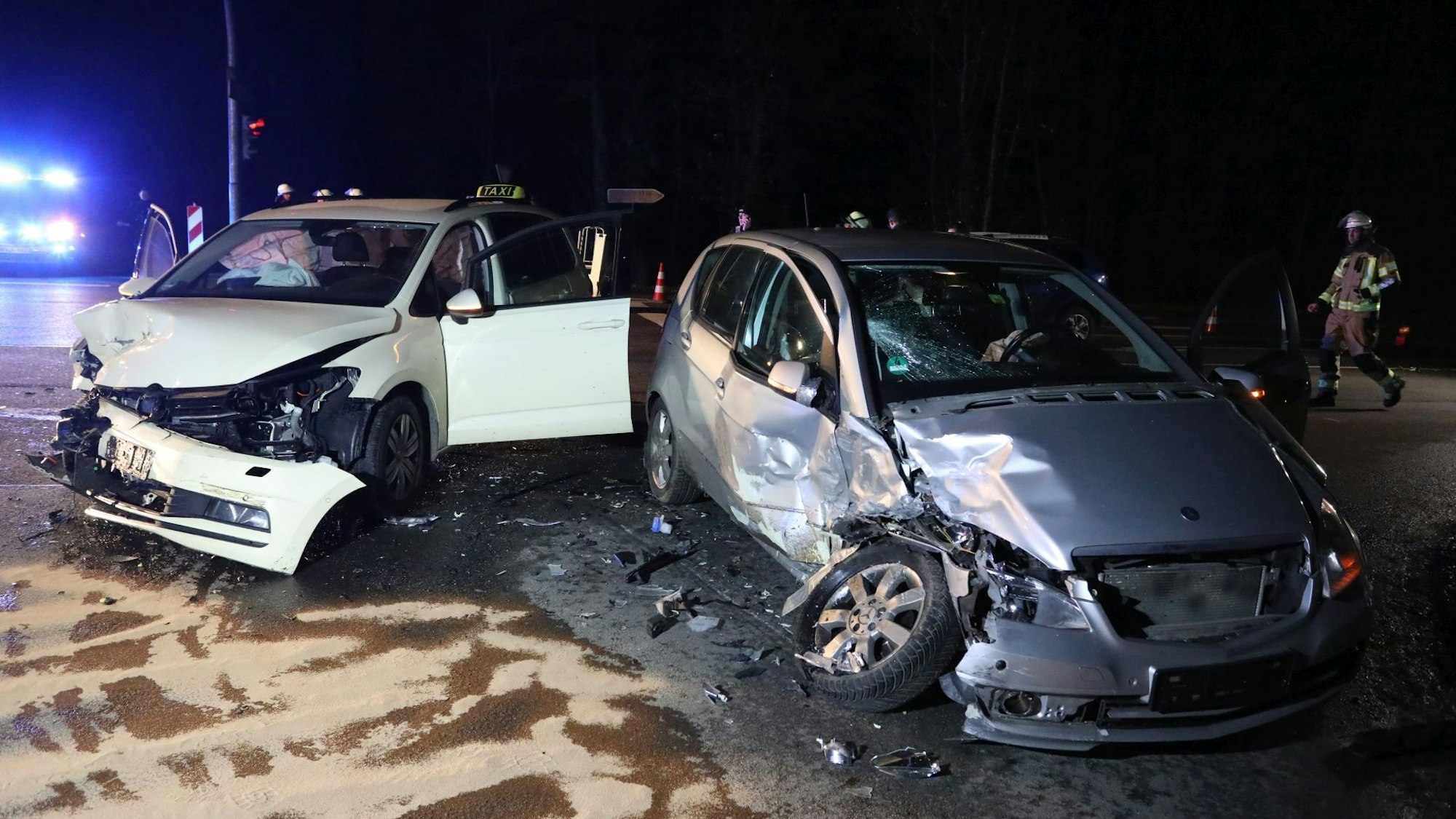 Zwei stark beschädigte Autos, im Hintergrund ein Feuerwehrmann.