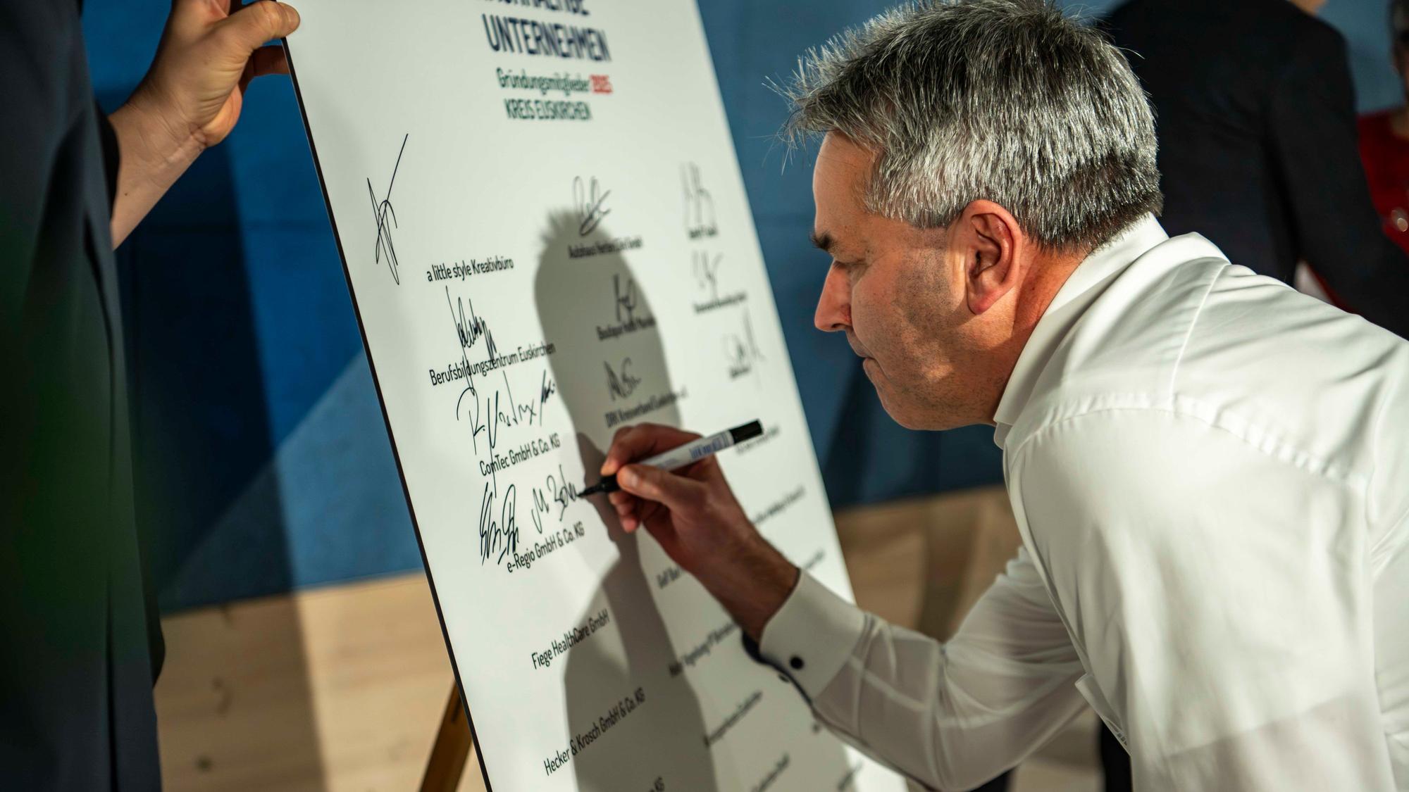 Das Bild zeigt Markus Böhm bei der Unterschrift.