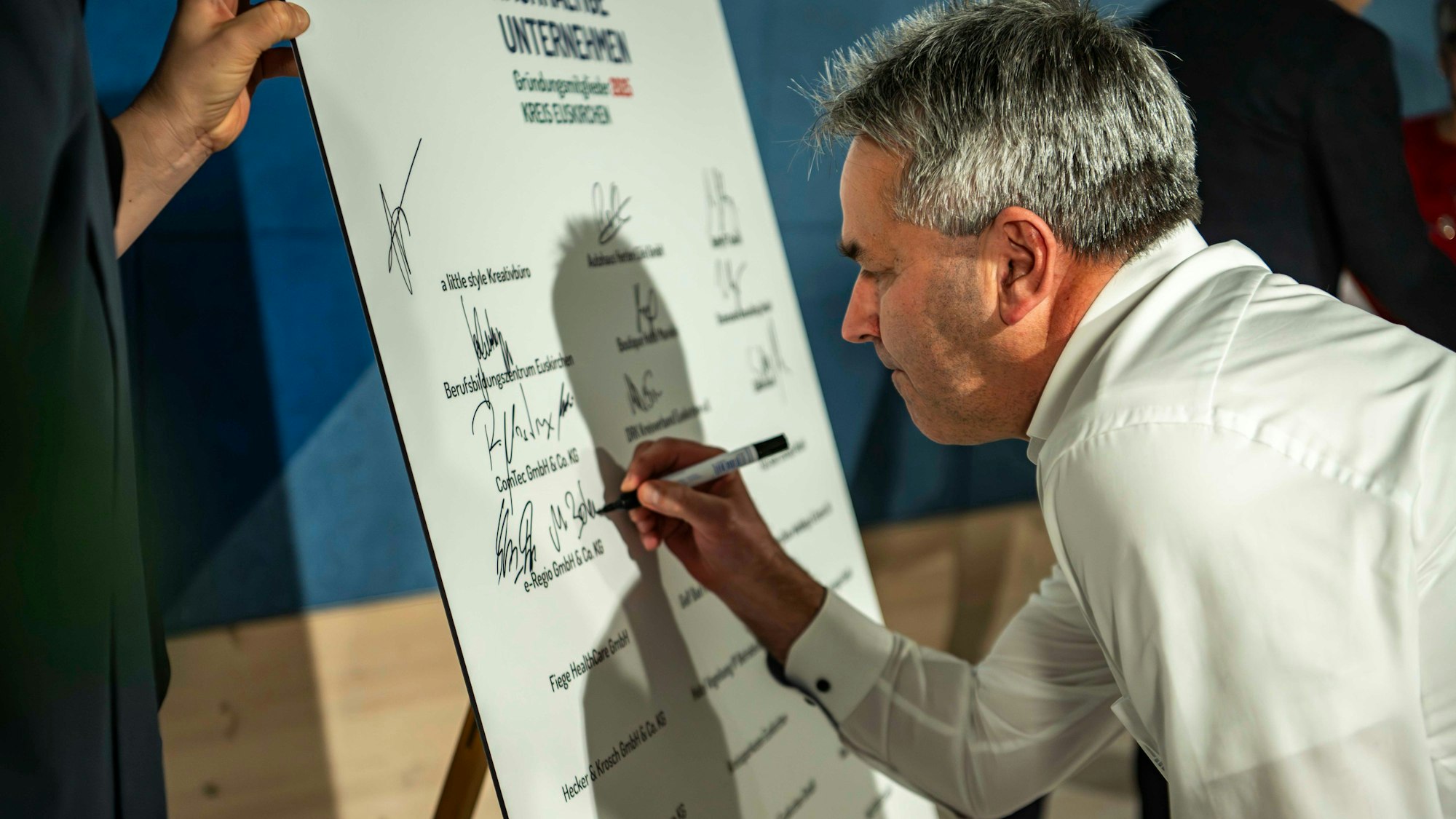 Das Bild zeigt Markus Böhm bei der Unterschrift.