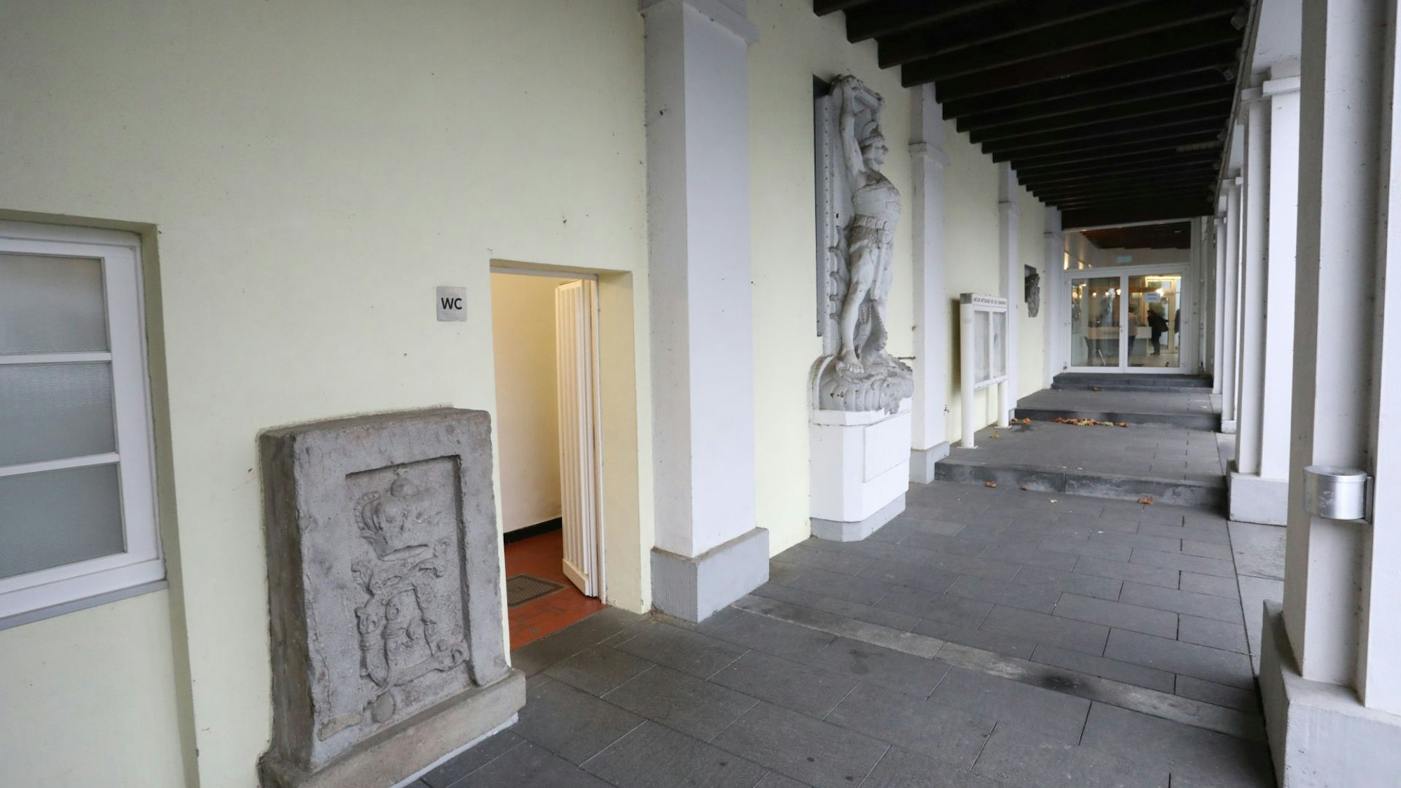 Ein Arkadengang, links der Eingang zu einer öffentlichen Toilette.