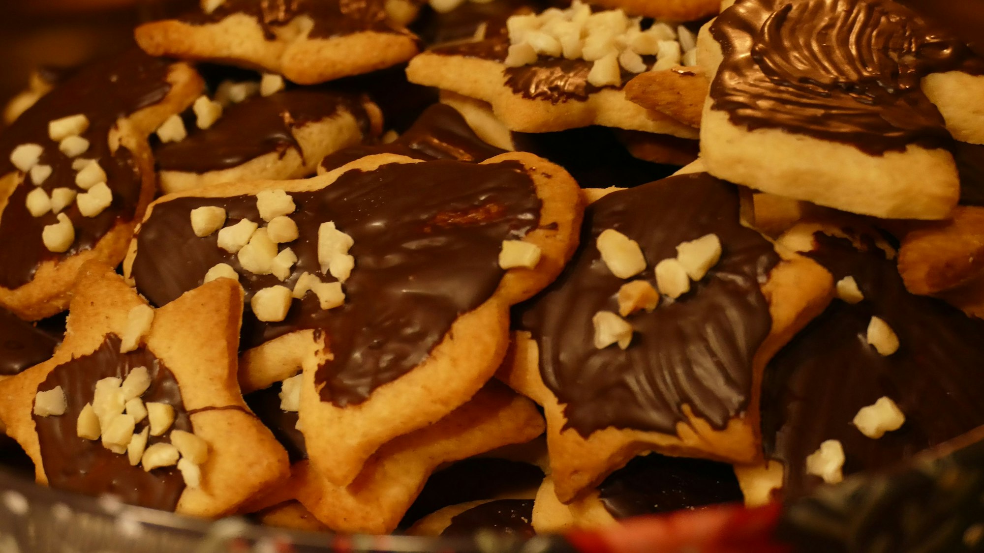 Die fertigen Mürbeteig-Plätzchen können mit Nüssen und Schokolade verziert werden.