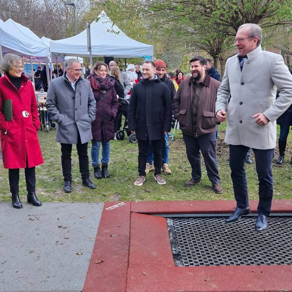 Zu sehen ist ein Mann auf einem Trampolin, um ihn herum stehen mehrere Menschen.