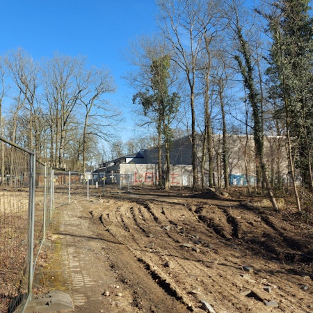 Eine Baustelle, dahinter ein Schulzentrum.