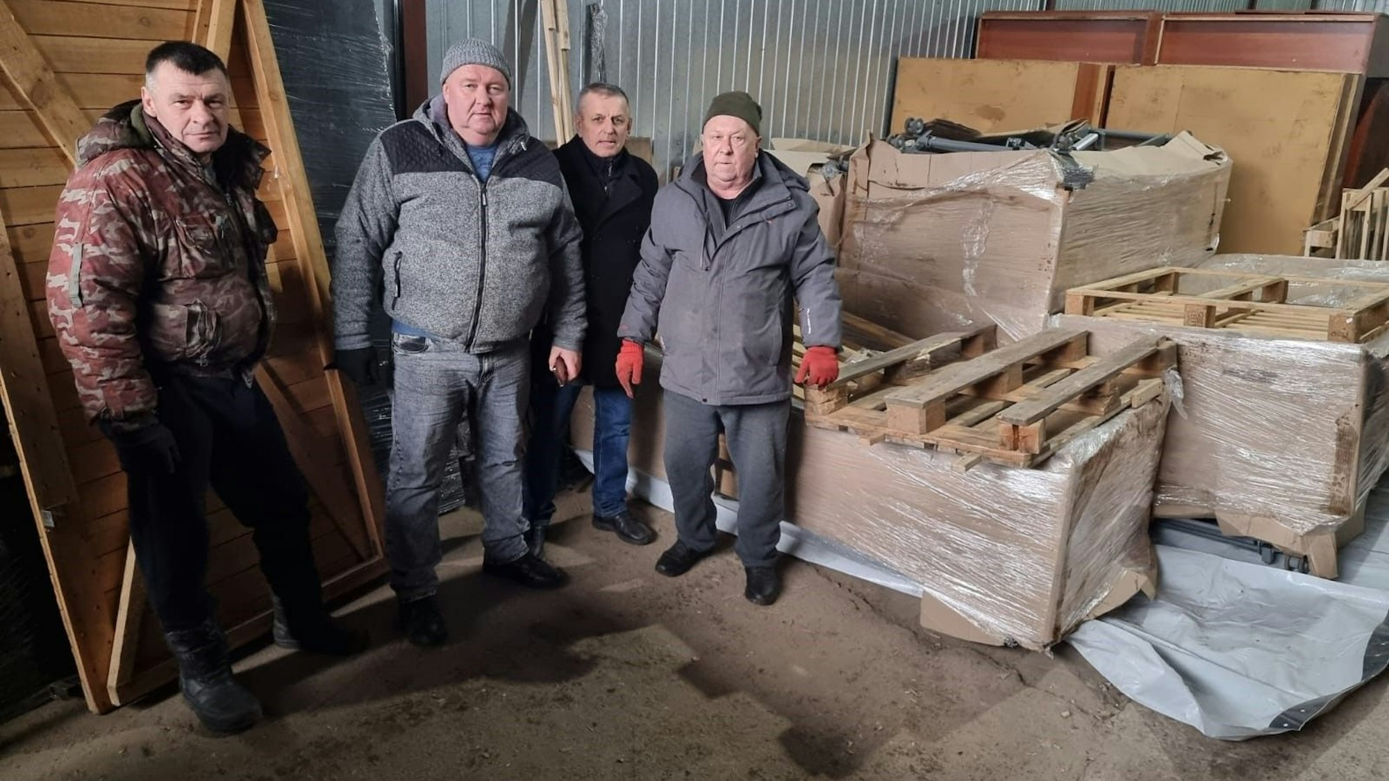 Hilfslieferungen aus Oberberg sind in Charkiw angekommen. Mehrere Männer laden und packen die Kisten aus.