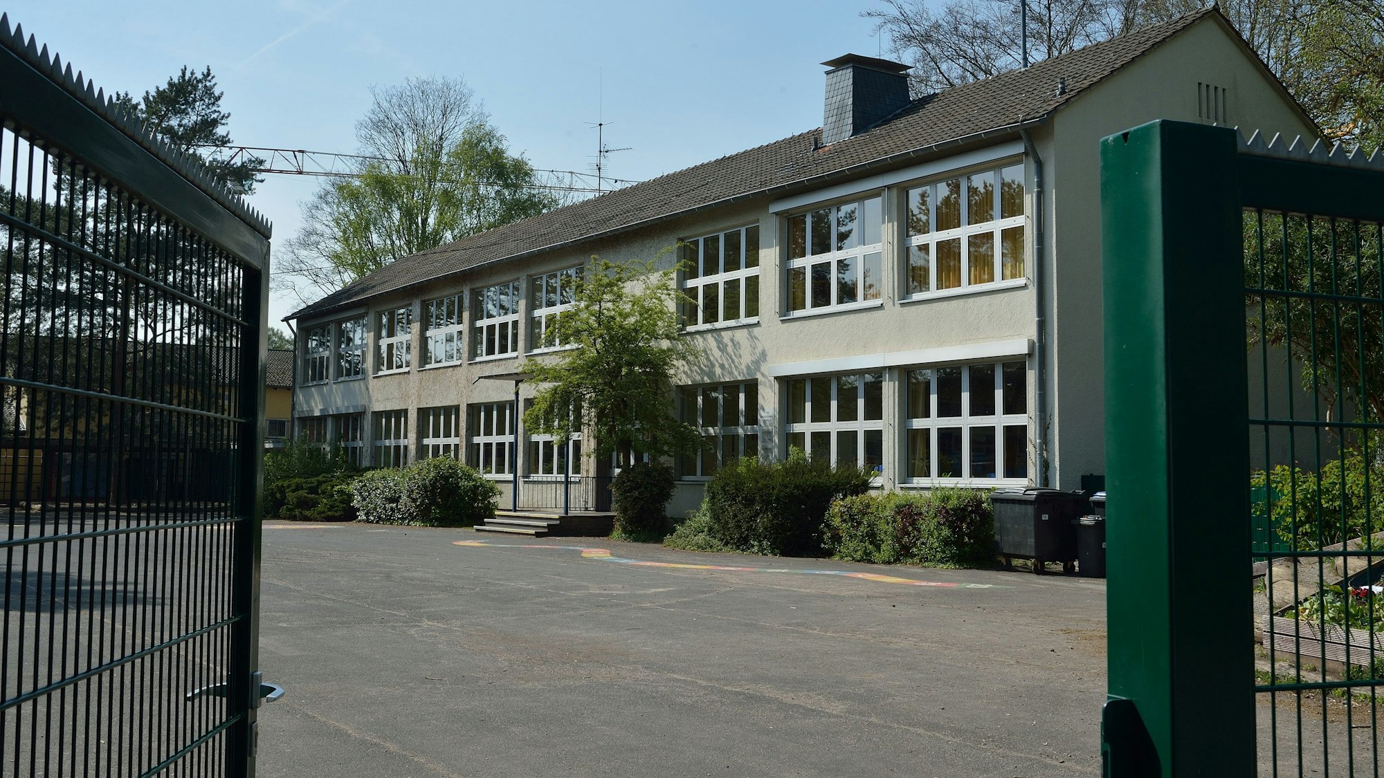 Das Schultor steht offen. Der Blick fällt auf das Hauptgebäude.