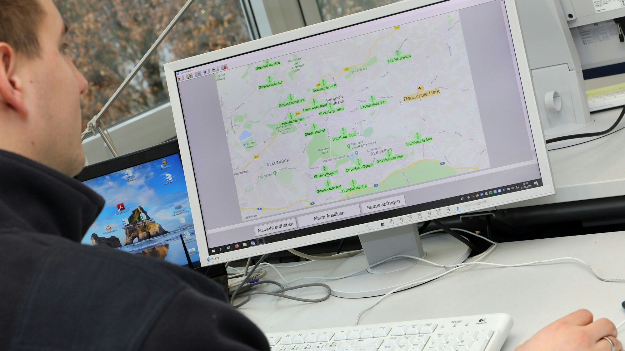 Projektleiter Simon Schwab sitzt vor einem Bildschirm, auf dem die Bergisch Gladbacher Sirenenstandorte zu sehen sind.